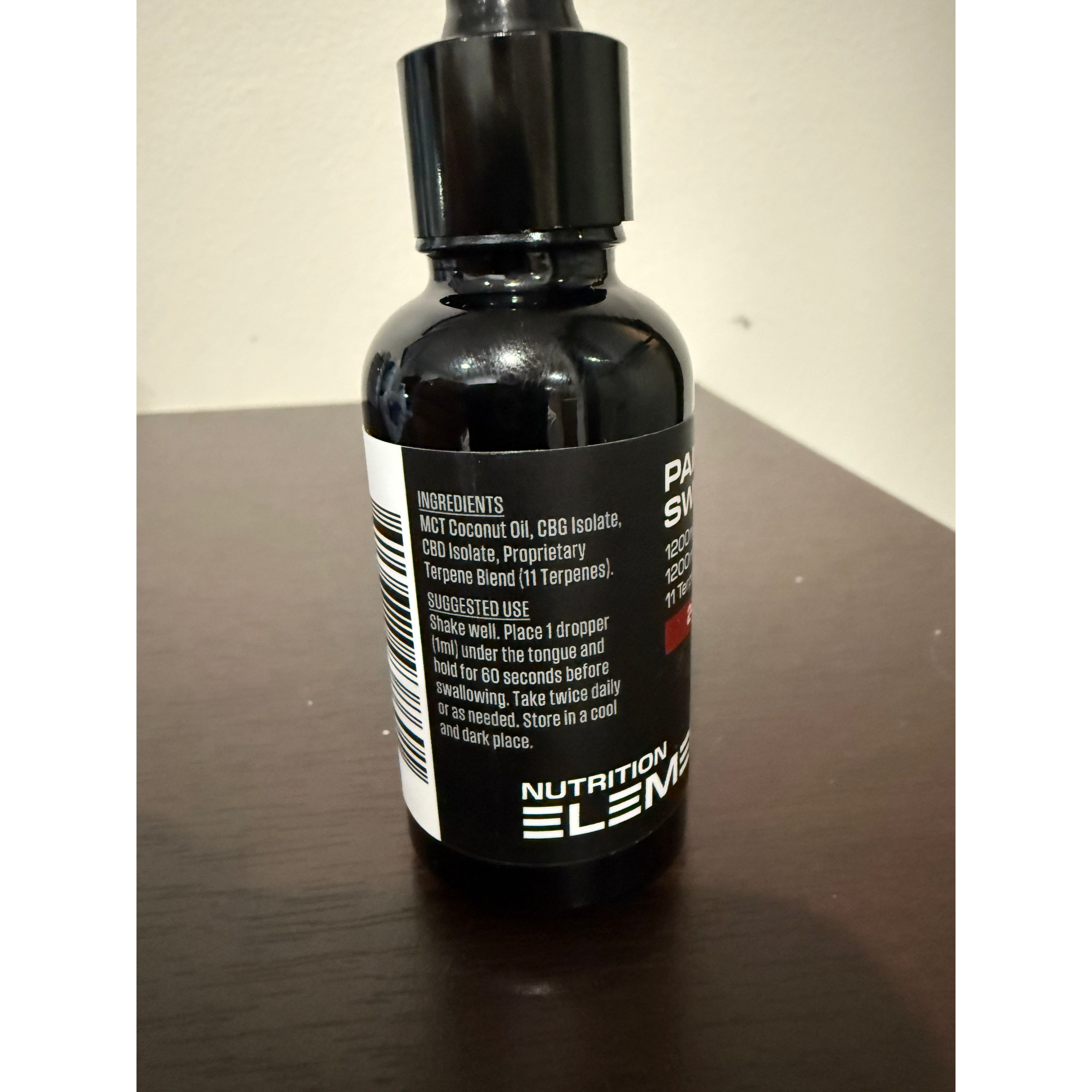 Black bottle with label on a dark surface