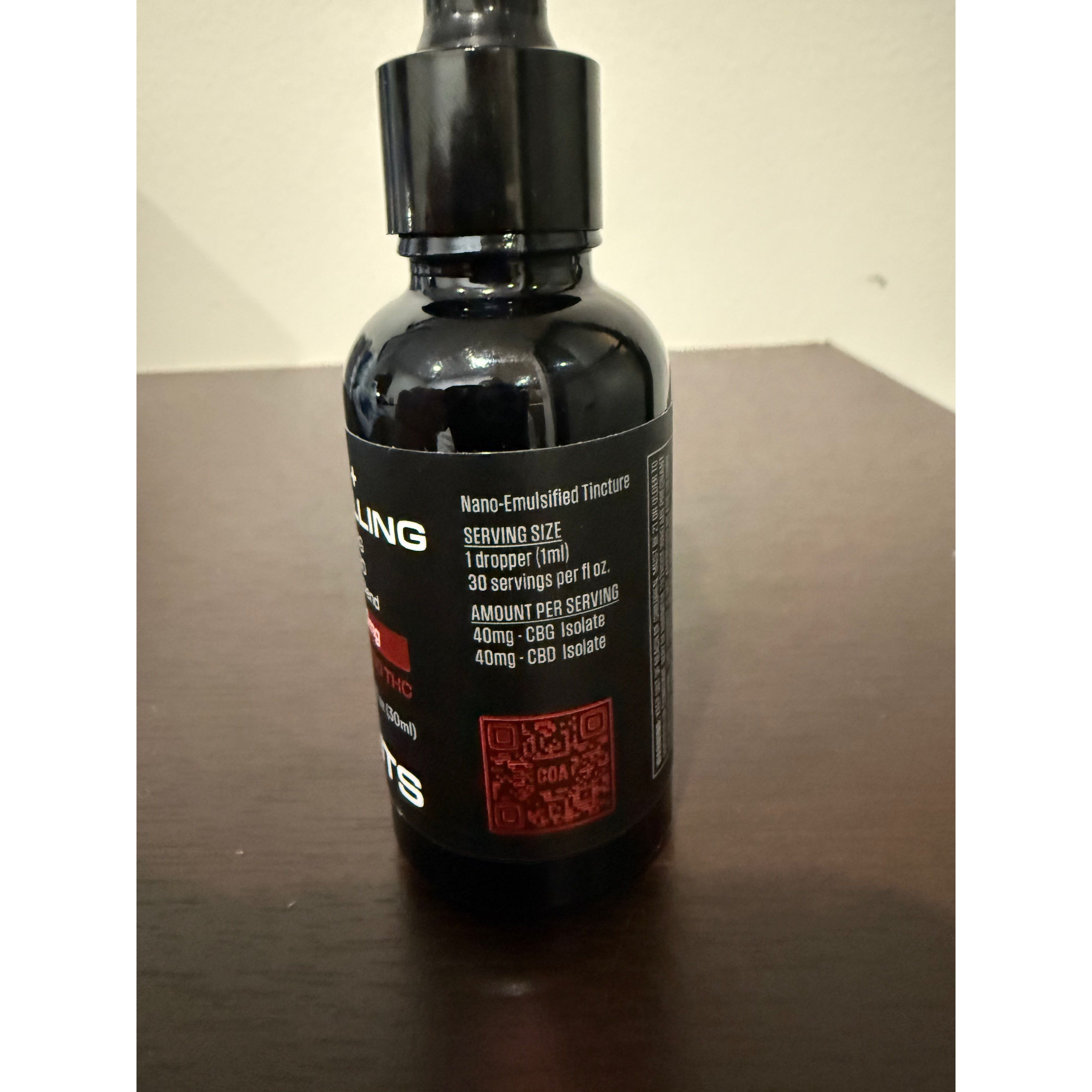 Black bottle with a label on a wooden surface