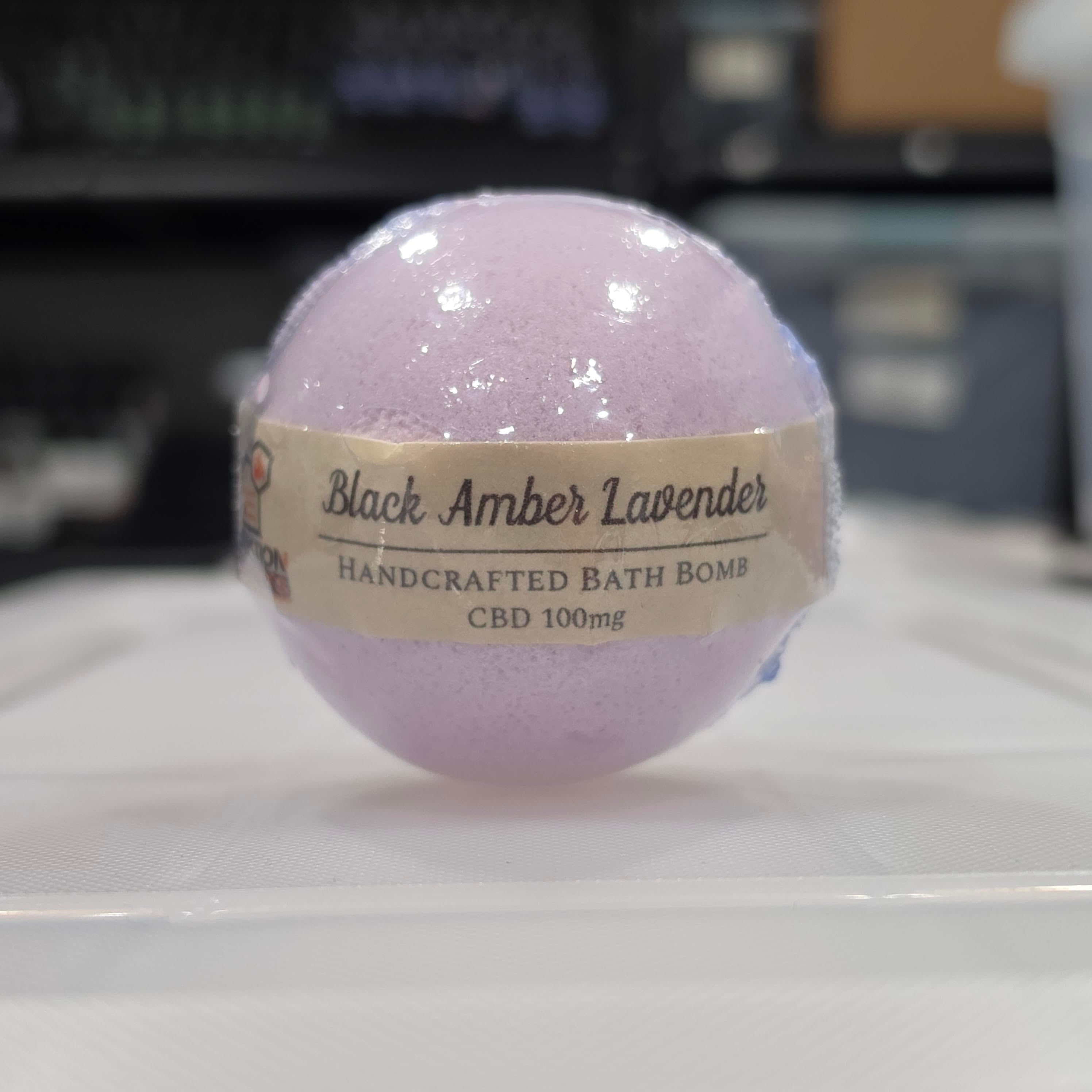 Purple bath bomb with a label on a white surface